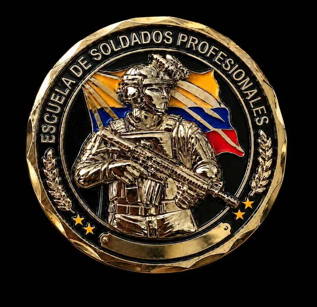 Moneda dorada con un soldado en alto relieve frente a la bandera de Colombia